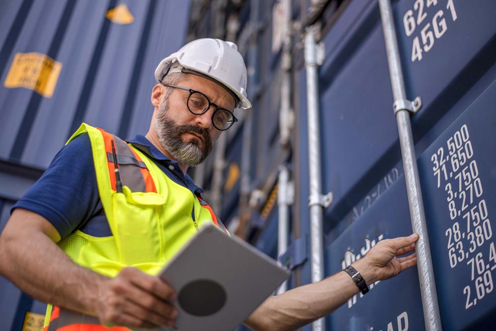 Man som inspekterar en container